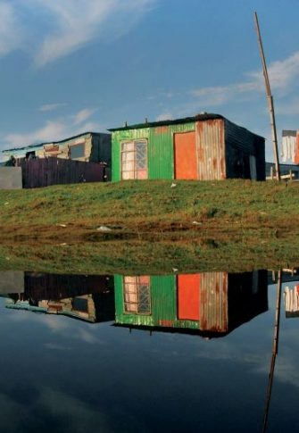 Masixole Feni Cape Town: A pool of water reflecting shack houses after a heavy rain over the Weekend, in Mfuleni Informal Settlement, 2015